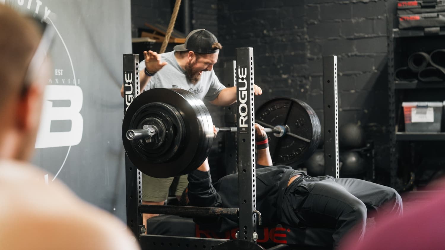 Member bench pressing with a spotter at Indy City Barbell, Indianapolis