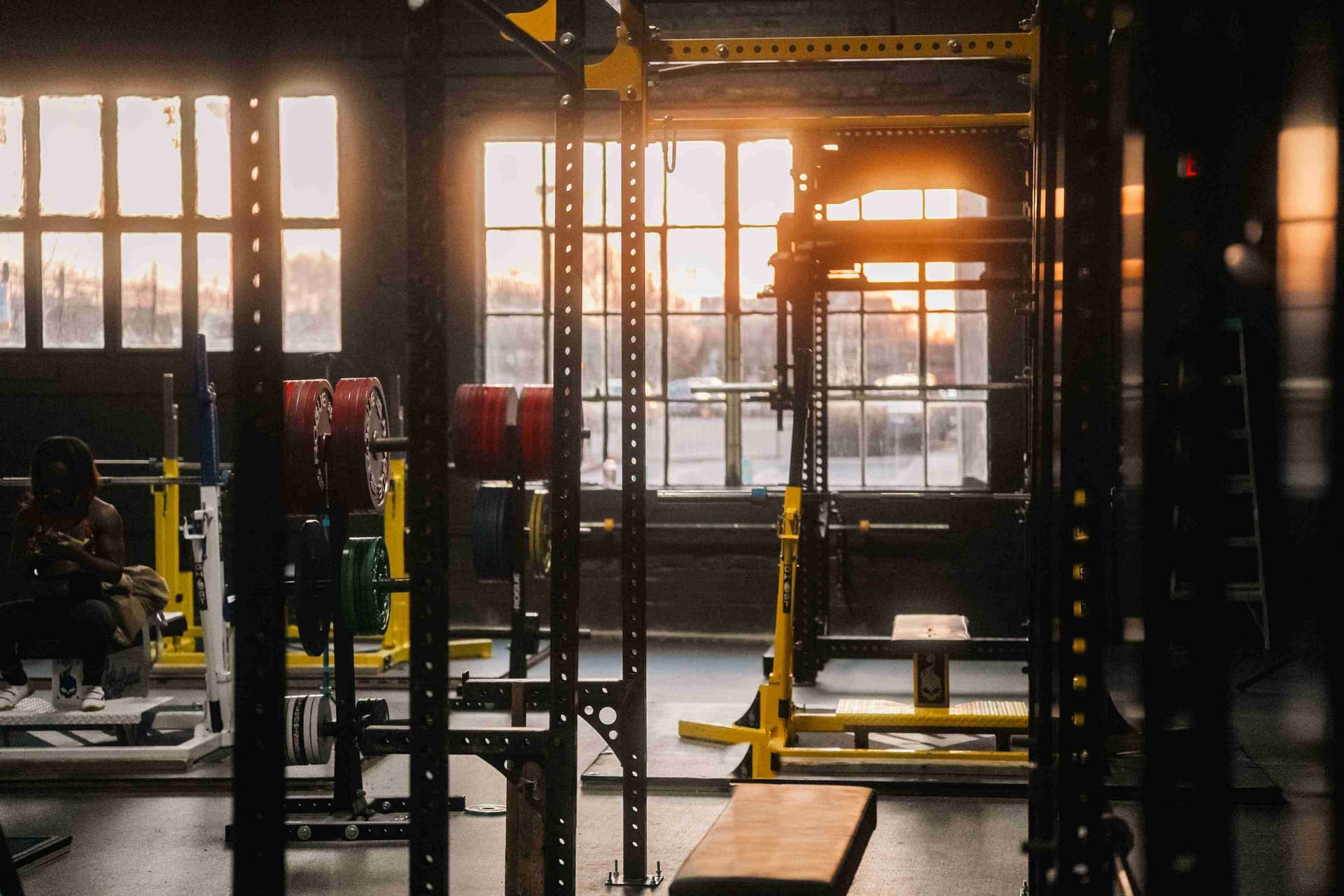 Strength training area with power racks and plates at Indy City Barbell